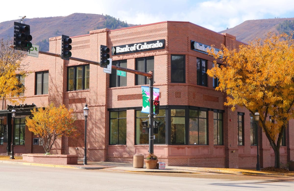 The Bank of Colorado building in Glenwood Springs, built by D.M. Neuman Construction, framed by autumn trees