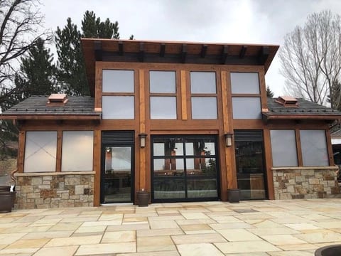 A timber-and-stone commercial storefront with a paved plaza