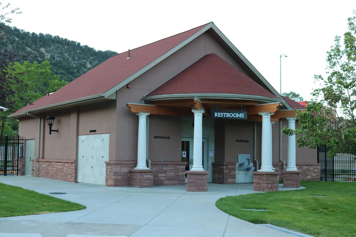 A columned public restroom building with a gabled roof