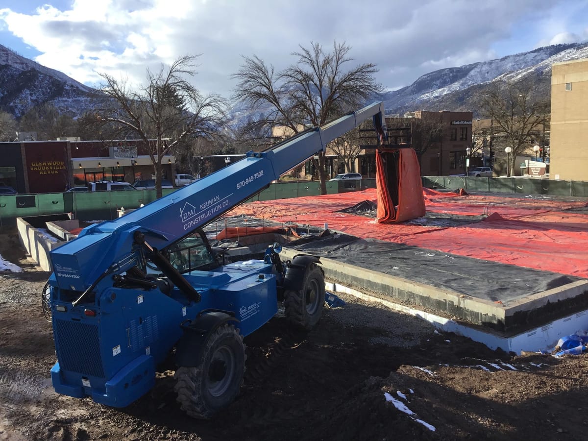 A telehandler working across a fresh slab on a commercial site