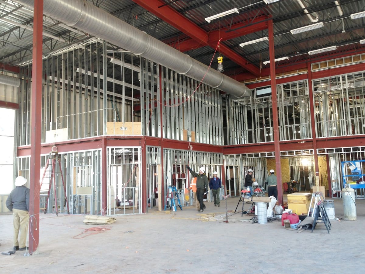 Steel stud framing rising inside a large commercial shell