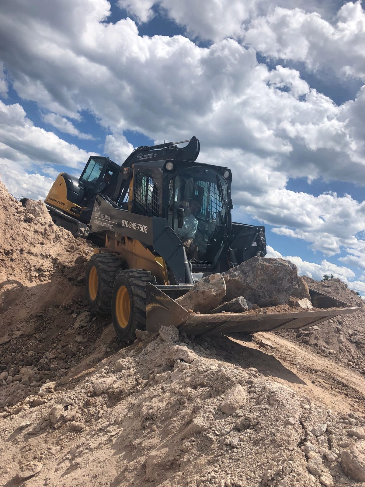 A skid steer moving earth on a Roaring Fork Valley building site