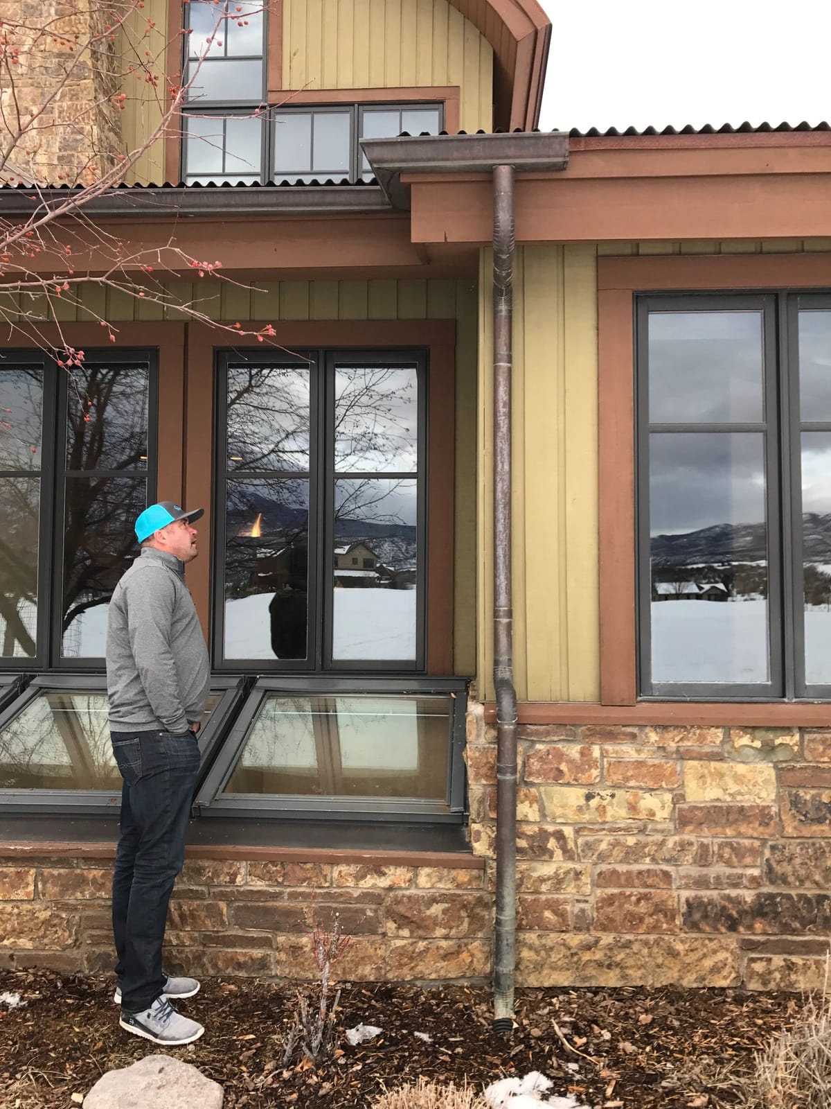A superintendent checking window installation on a finished elevation