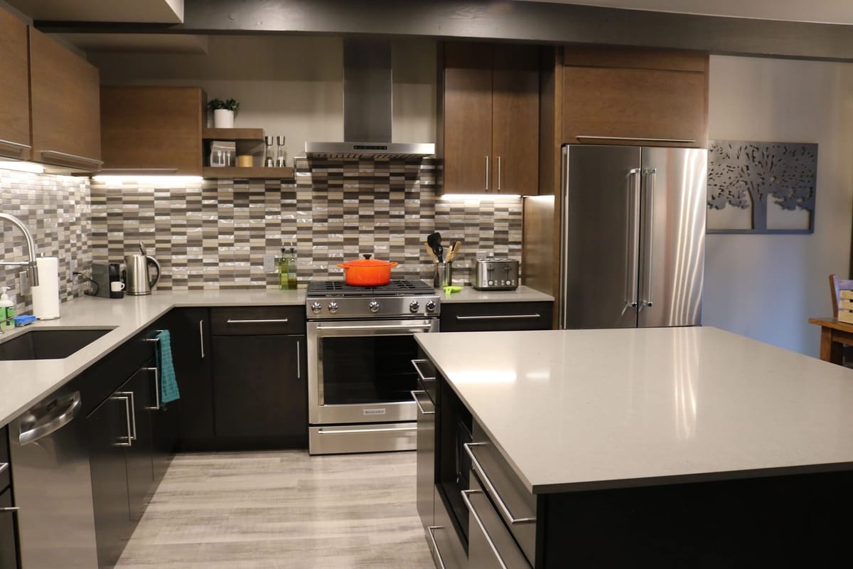 A custom kitchen in dark cabinetry with a quartz peninsula