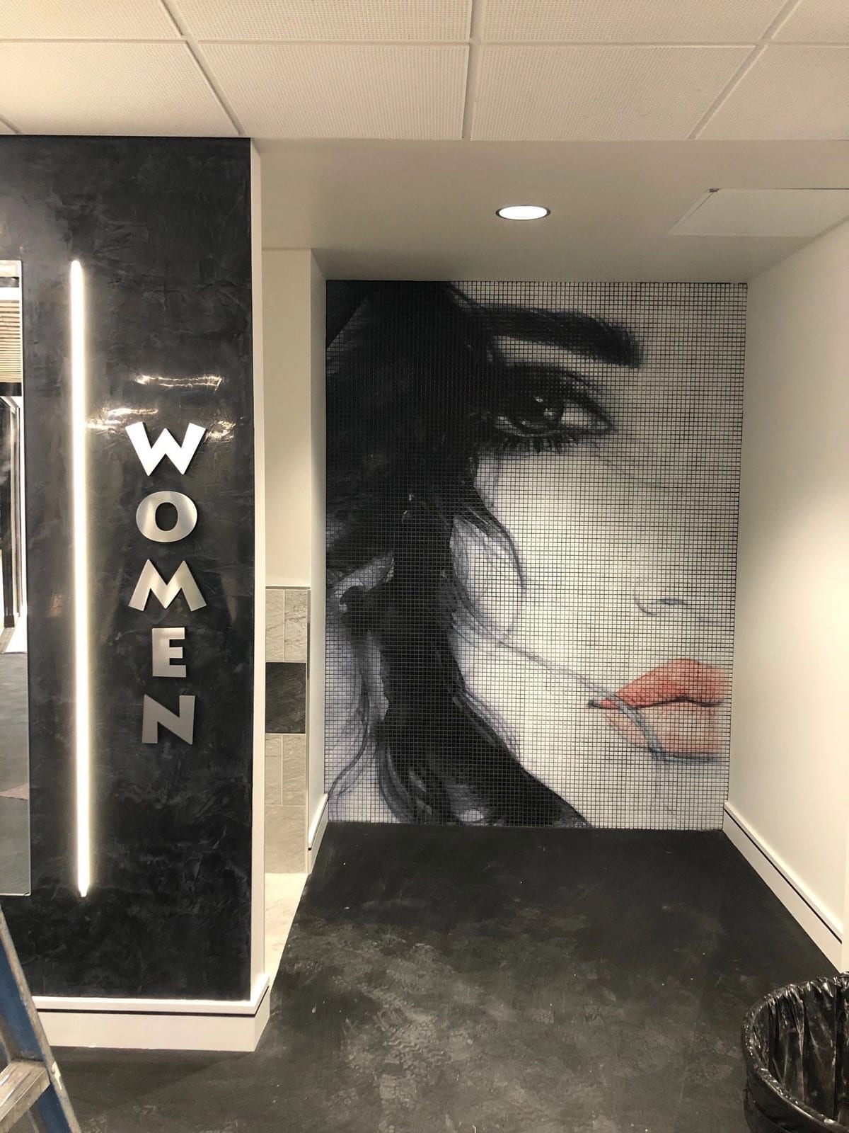 A tiled mosaic feature wall at the entrance to a fitness club locker room