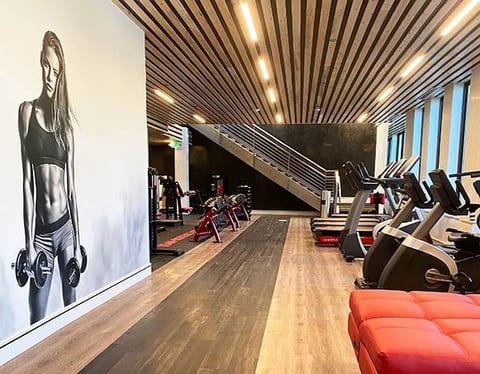 A fitness club interior with timber slat ceilings and a full-height mural