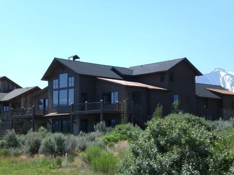 The rear elevation of a dark modern home with mountain views
