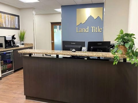 The Land Title reception desk in stone and dark timber